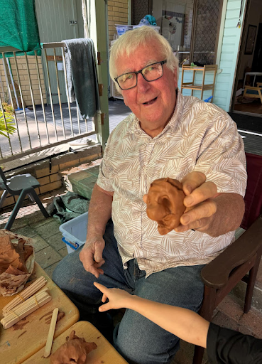 A Grand Friend and child sharing a close moment with clay