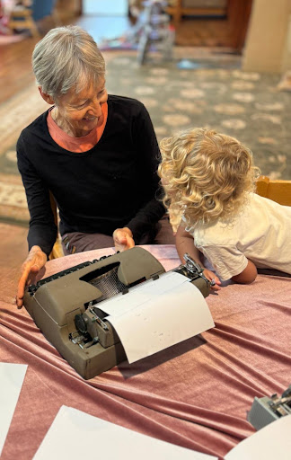 A child exploring a vintage typewriter with a Grand Friend