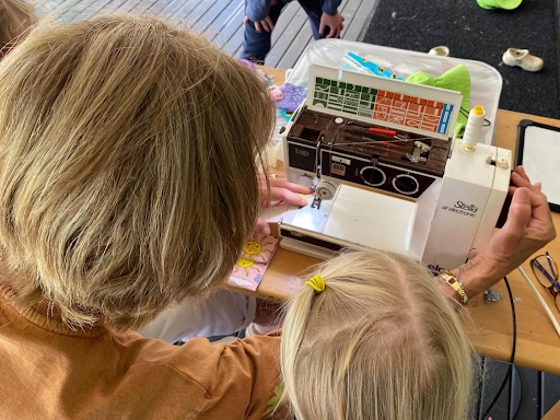 A Grand Friend sewing with a child