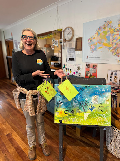 An educator displaying collaborative artwork