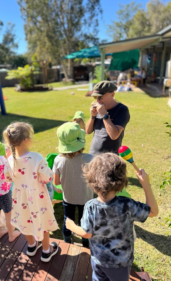 A Grand Friend playing harmonica with children