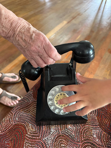 A child exploring a rotary phone with a Grand Friend